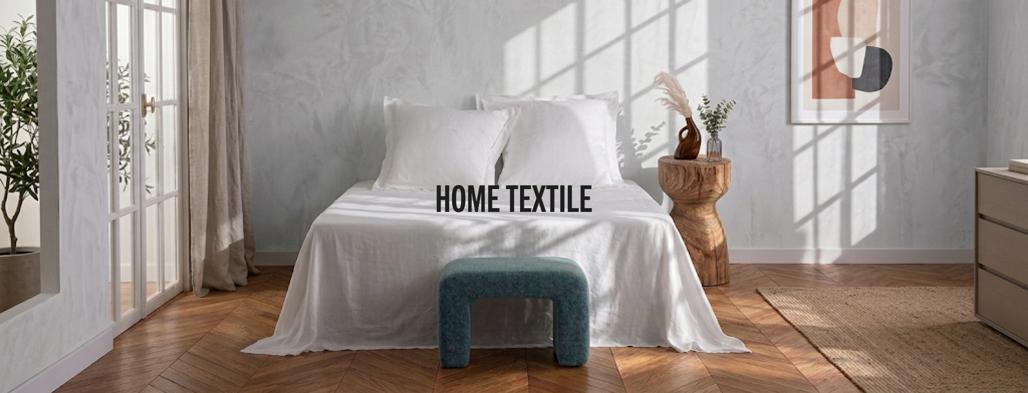 A styled bedroom scene with a bed dressed in white bedding, a blue upholstered bench at the foot, and the words 'HOME TEXTILE' overlaid across the center. The room has pale patterned walls, wood flooring, curtains, and natural light coming from a window.